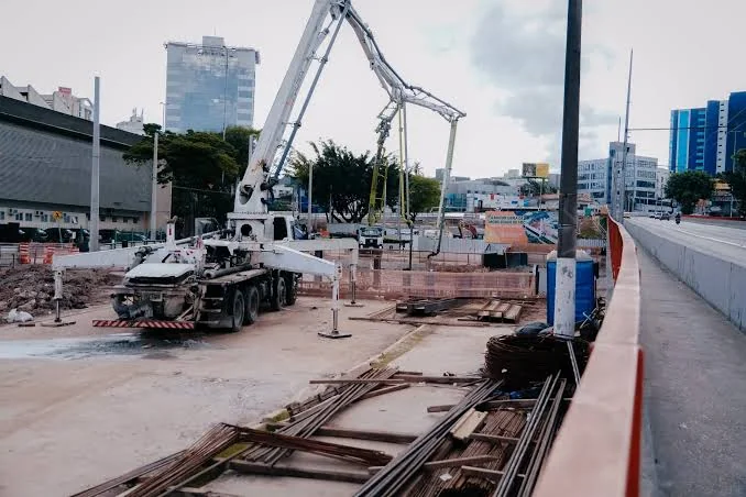 Caminhão com bomba lança posicionado para concretagem em obra urbana
